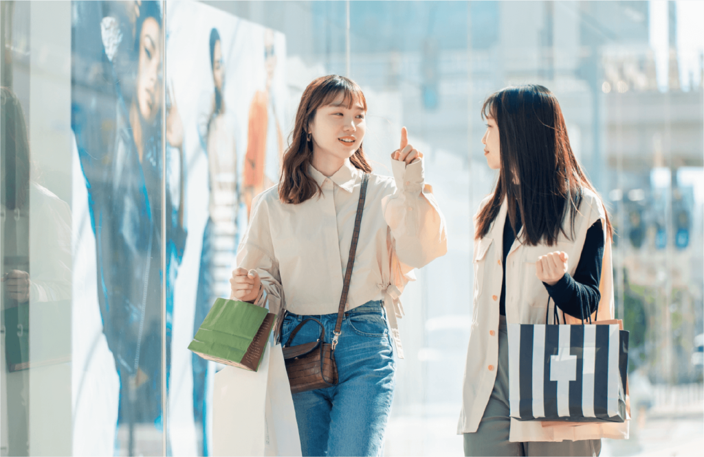 イメージ画像　会話をしながら街でショッピングをする2人の若い女性